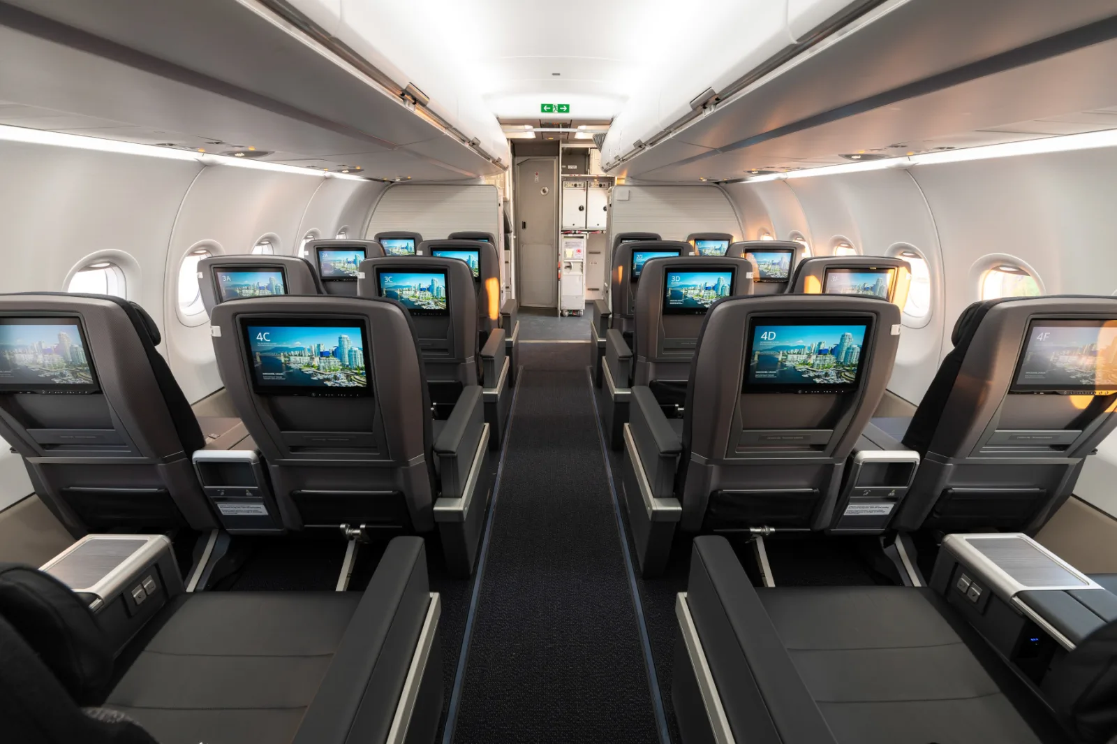 Rows of identical seat-back screens down a narrow-body cabin aisle, every one displaying the same information.