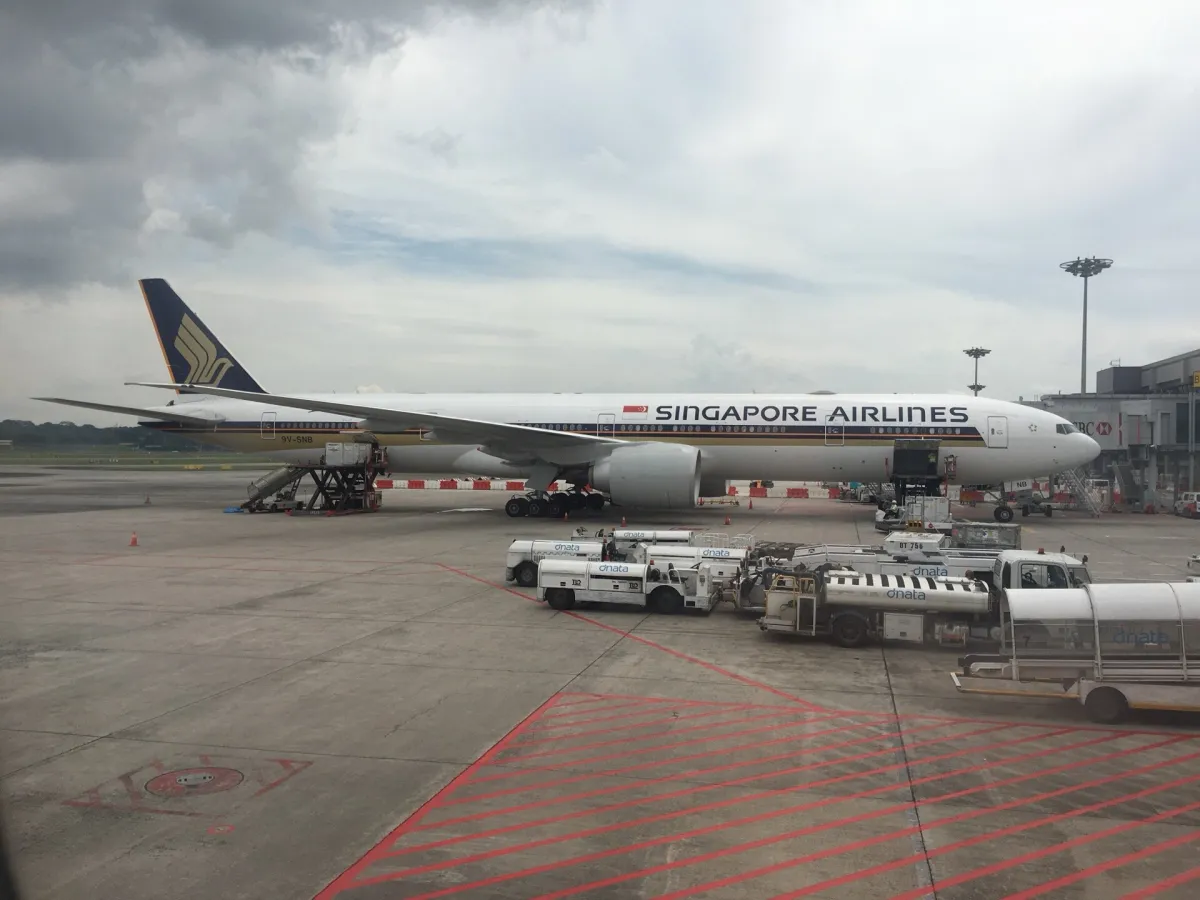Singapore Airlines Boeing 777-300ER in full profile at Singapore Changi Airport, white fuselage with gold cheatline